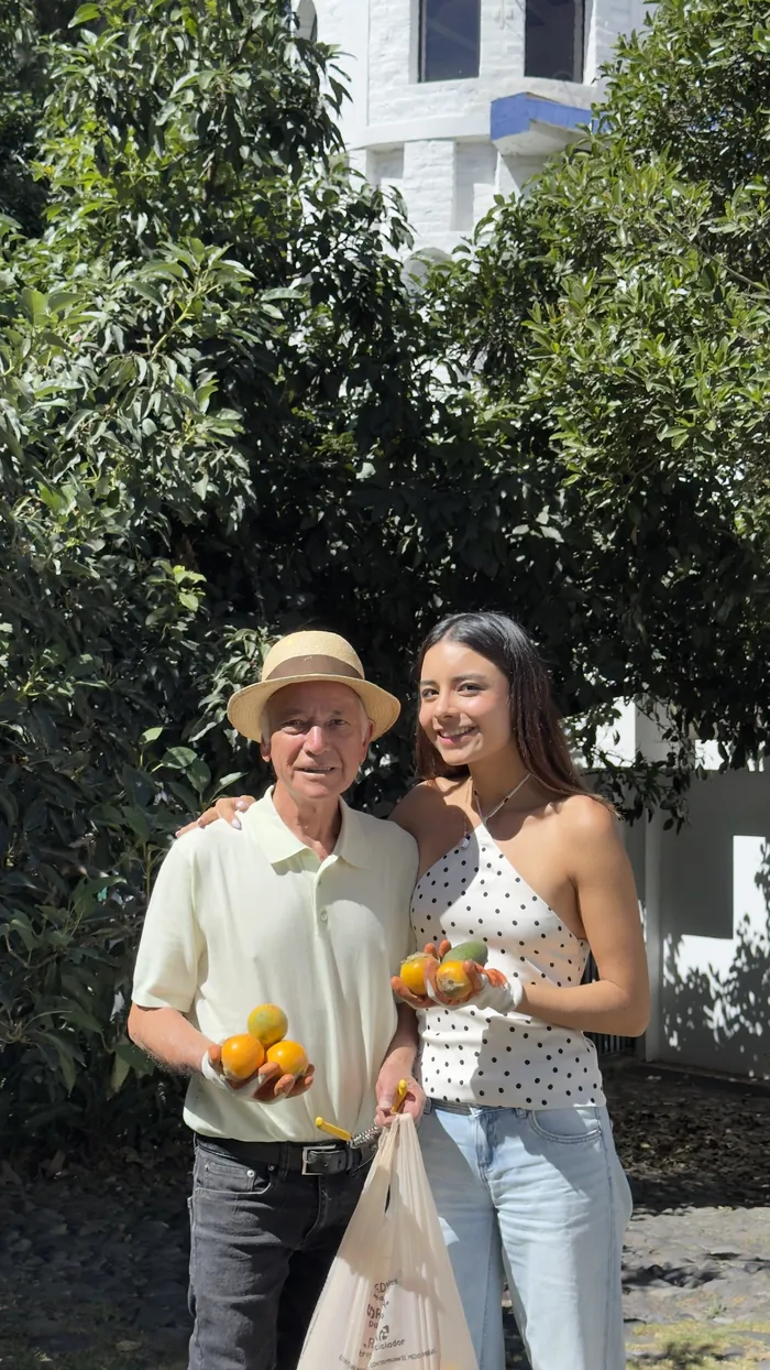 Carlos y su nieta posando con las naranjas recién recogidas del jardín.